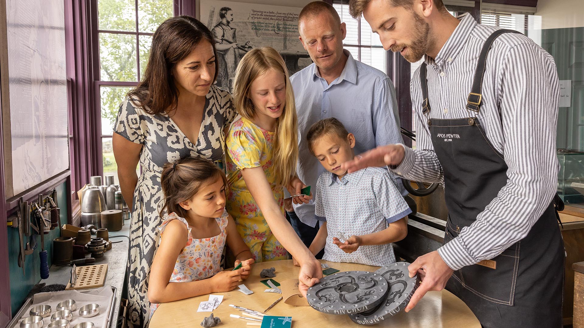 A family of four take part in the Amos Experience with one of the talented Artisans at Amos Pewter