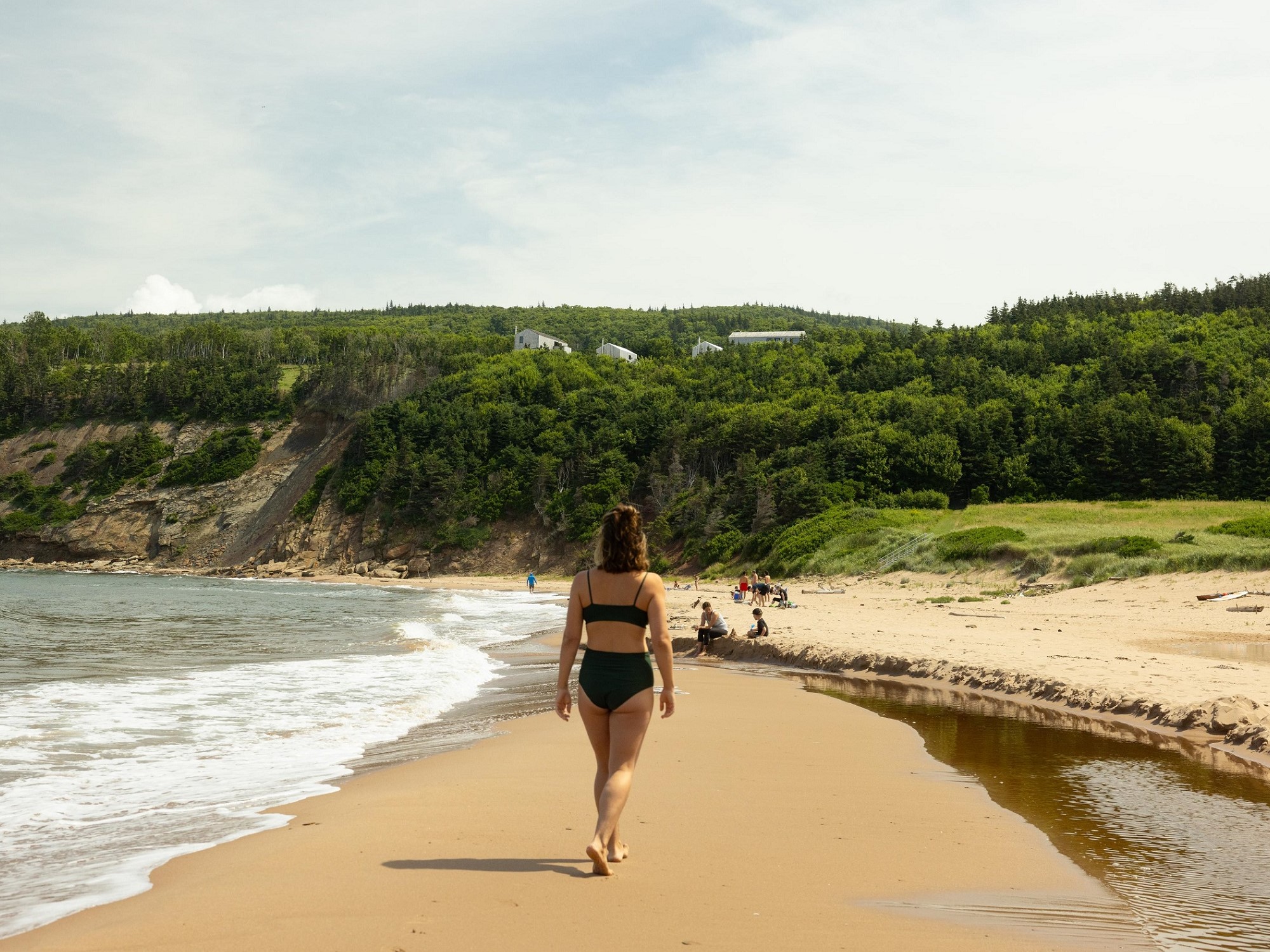 A woman walks along a sandy beach