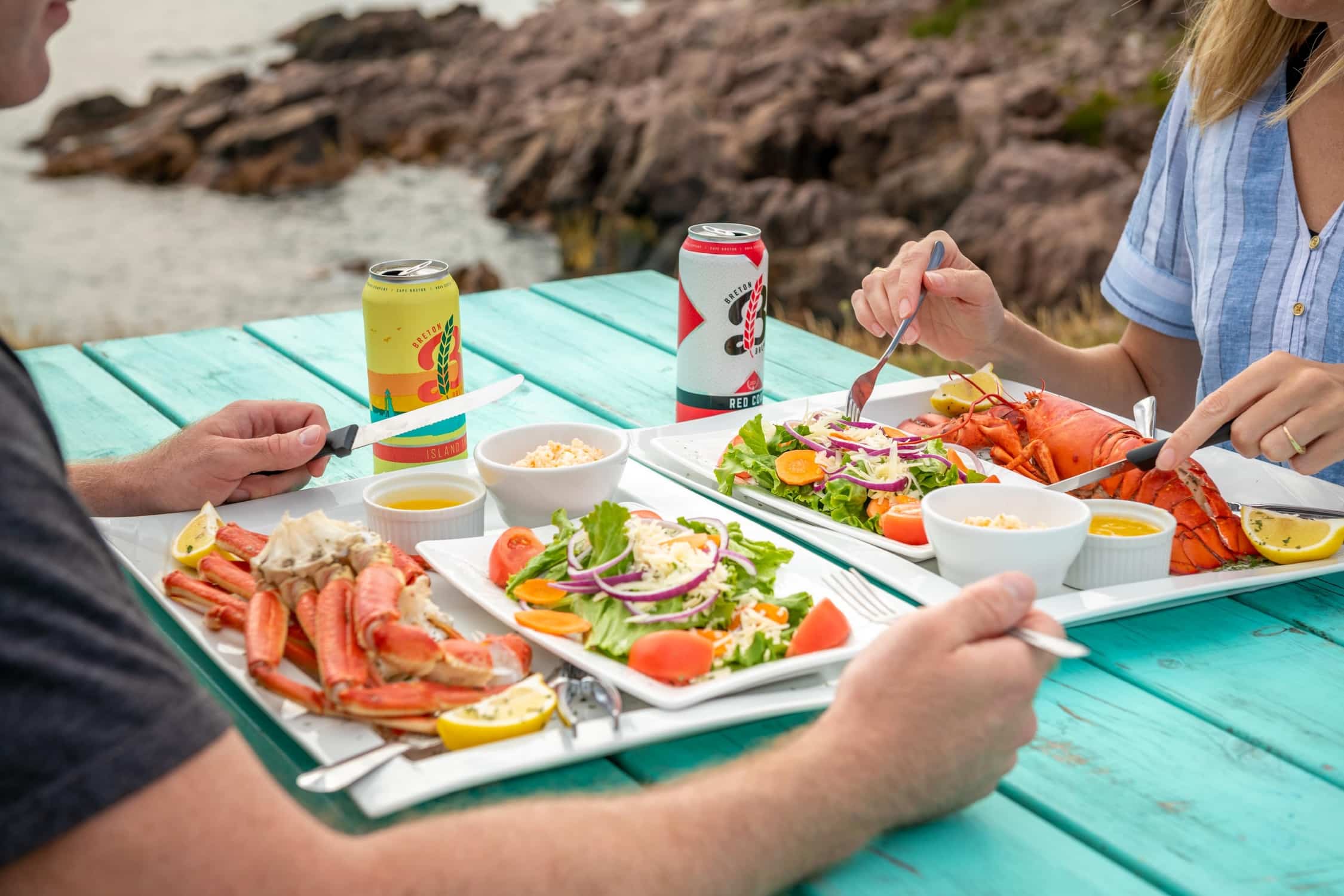 People eating lobster and crab by the ocean