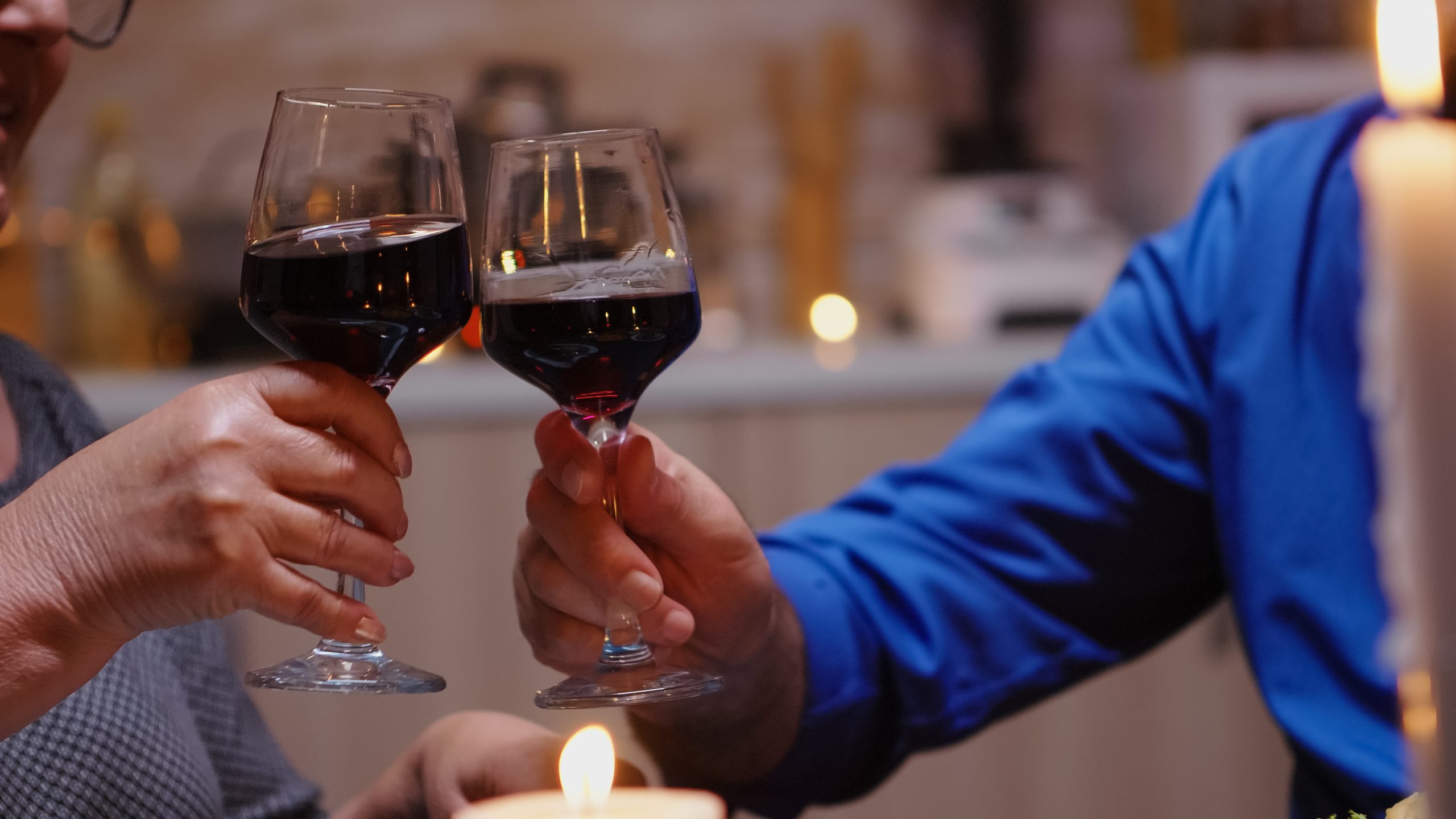 Two glasses full of red wine cheers.