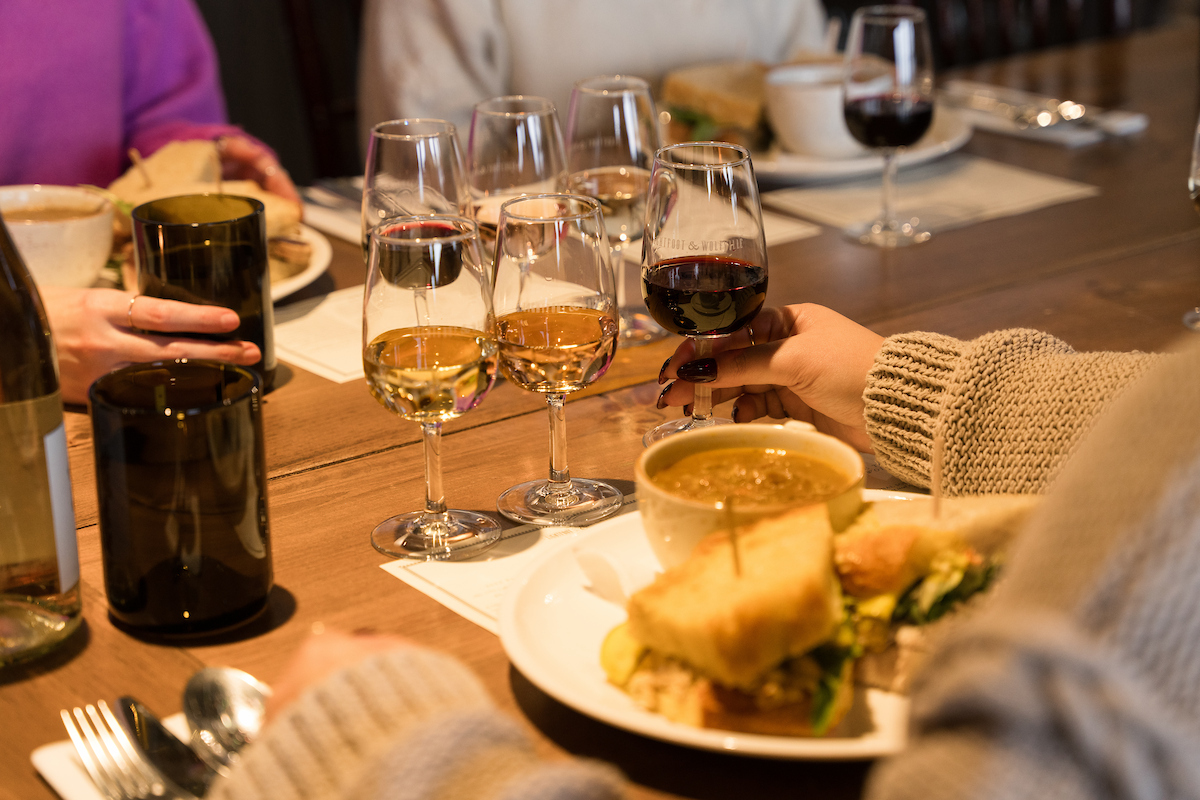 A table setting with people enjoying lunch and a wine flight.