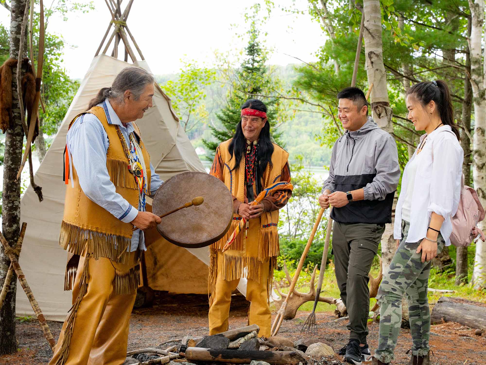 Two Mi'kmaw interpreters sharing their culture and history with two visitors taking part in the immersive experience on Goat Island with Eskasoni Cultural Experience in Cape Breton Nova Scotia.
