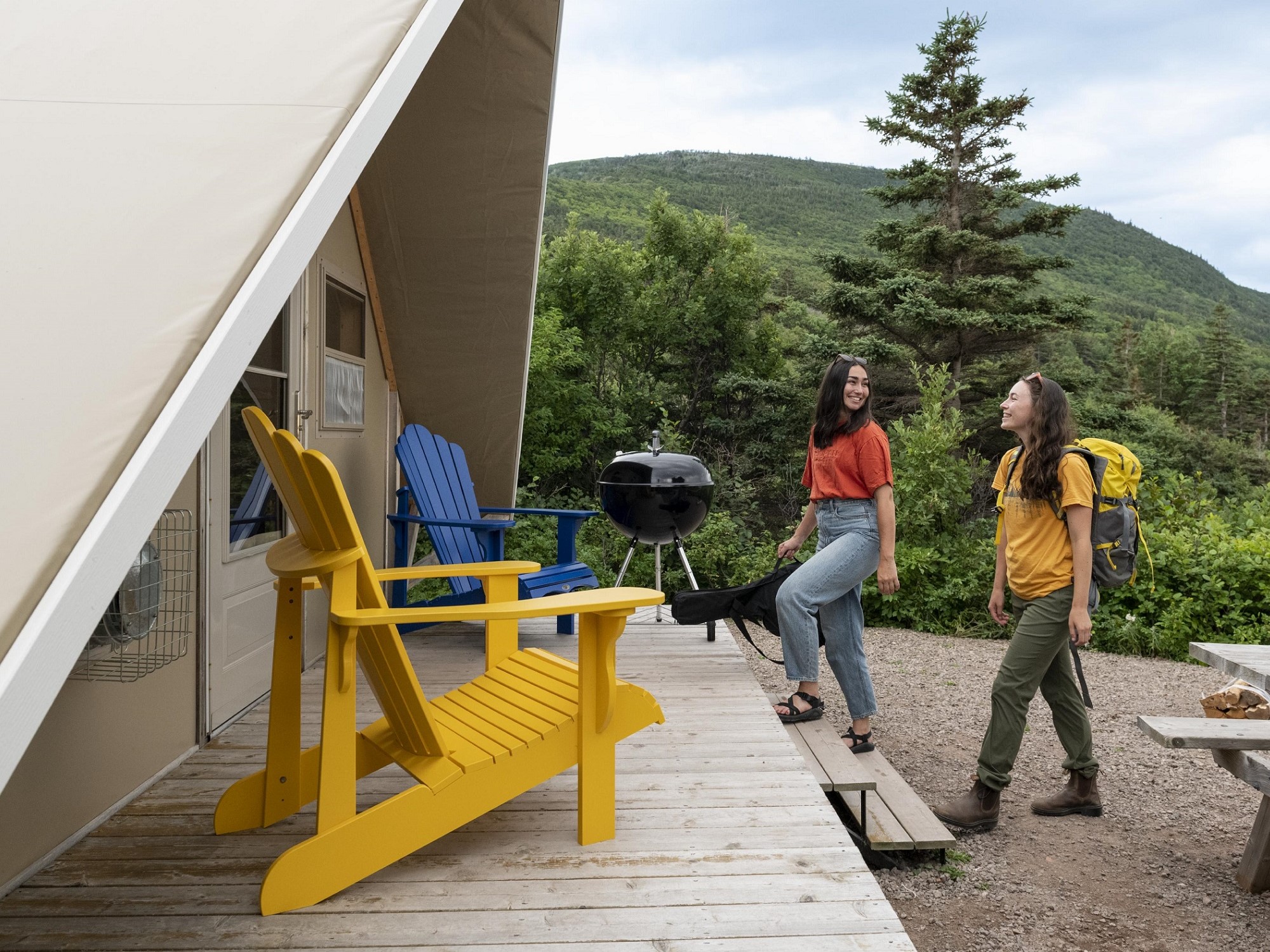 Two people enter an otentik for a camping trip.