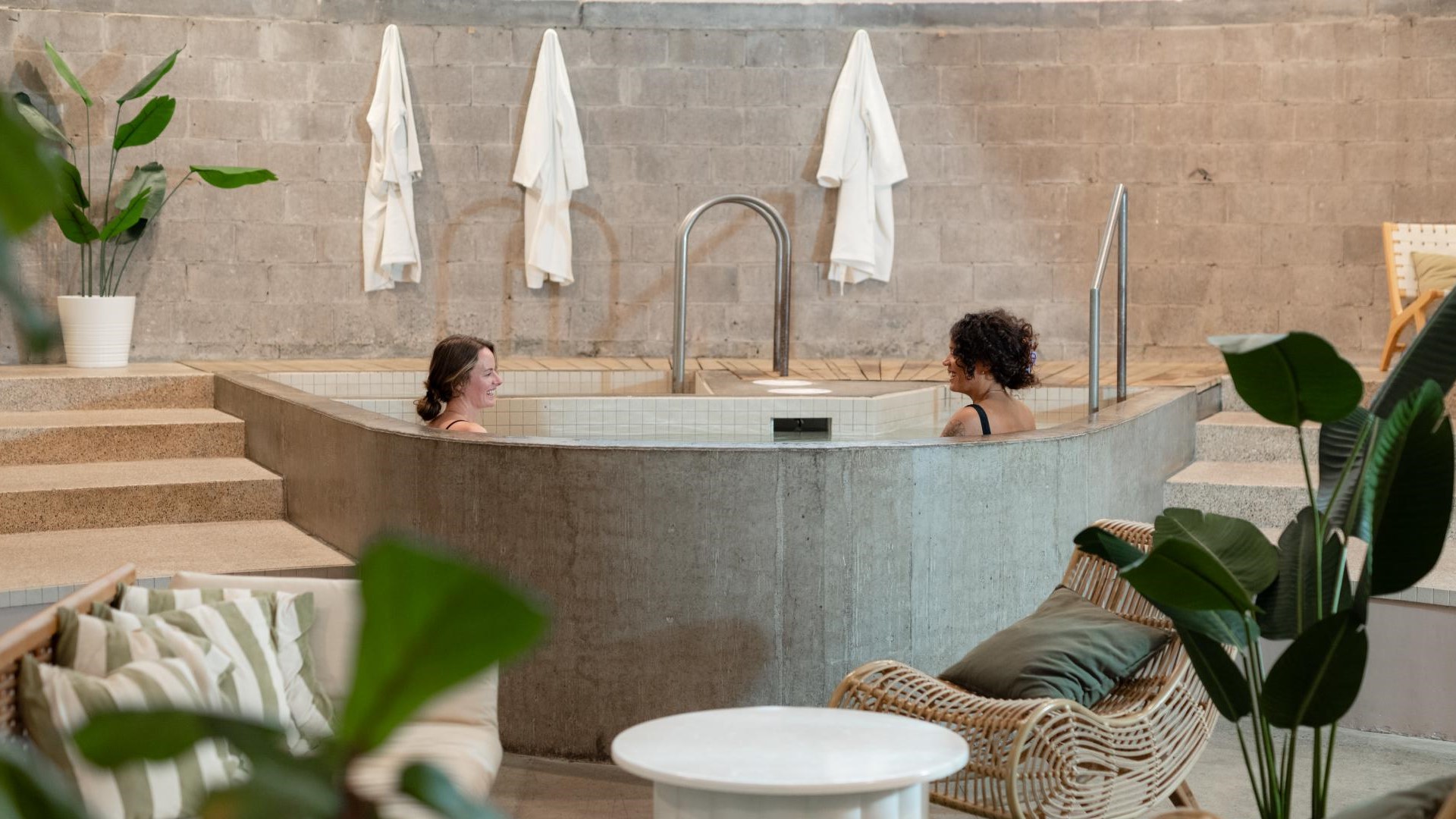 Two women relax in a pool at a nordic spa.