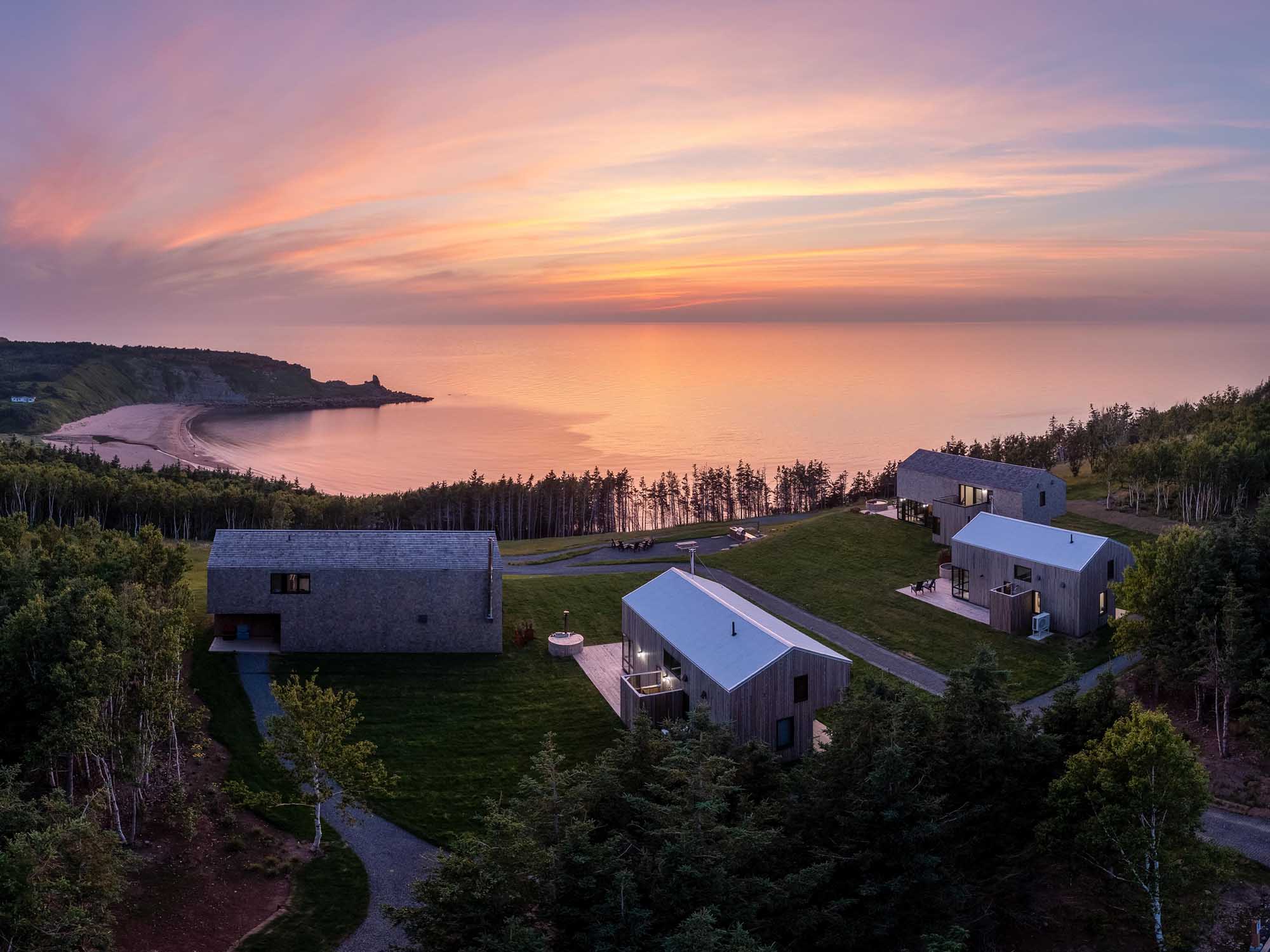 Aerial view over Ridge on the Chimney cabins as the sun sets on the Northumberland Strait over the sandy beach and four season retreat on Cape Breton Island in Nova Scotia.