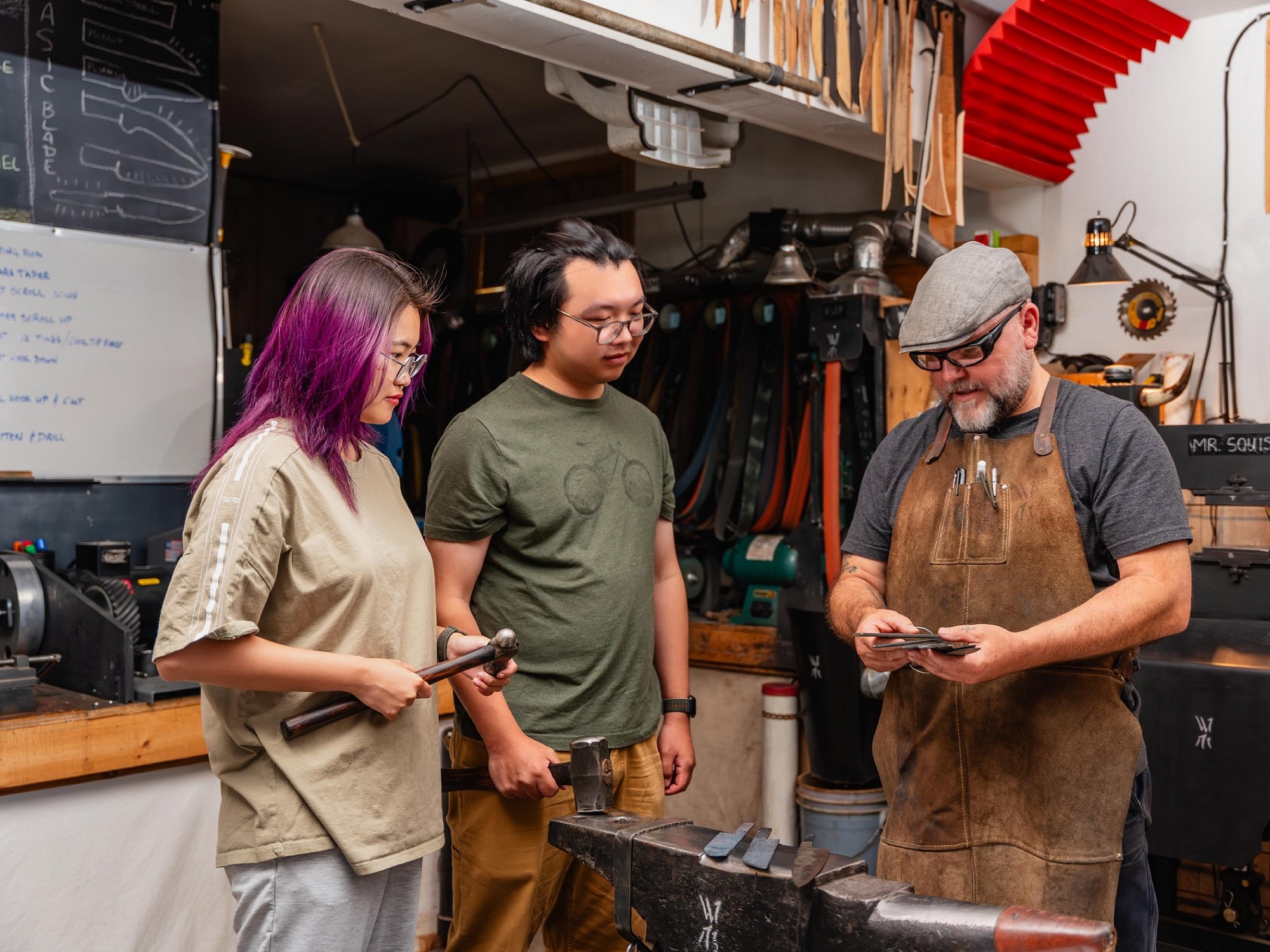 Two people observe a knife making demonstration at Wildertools