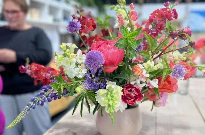 A large, colourful, bouquet of flowers sits in a vase.
