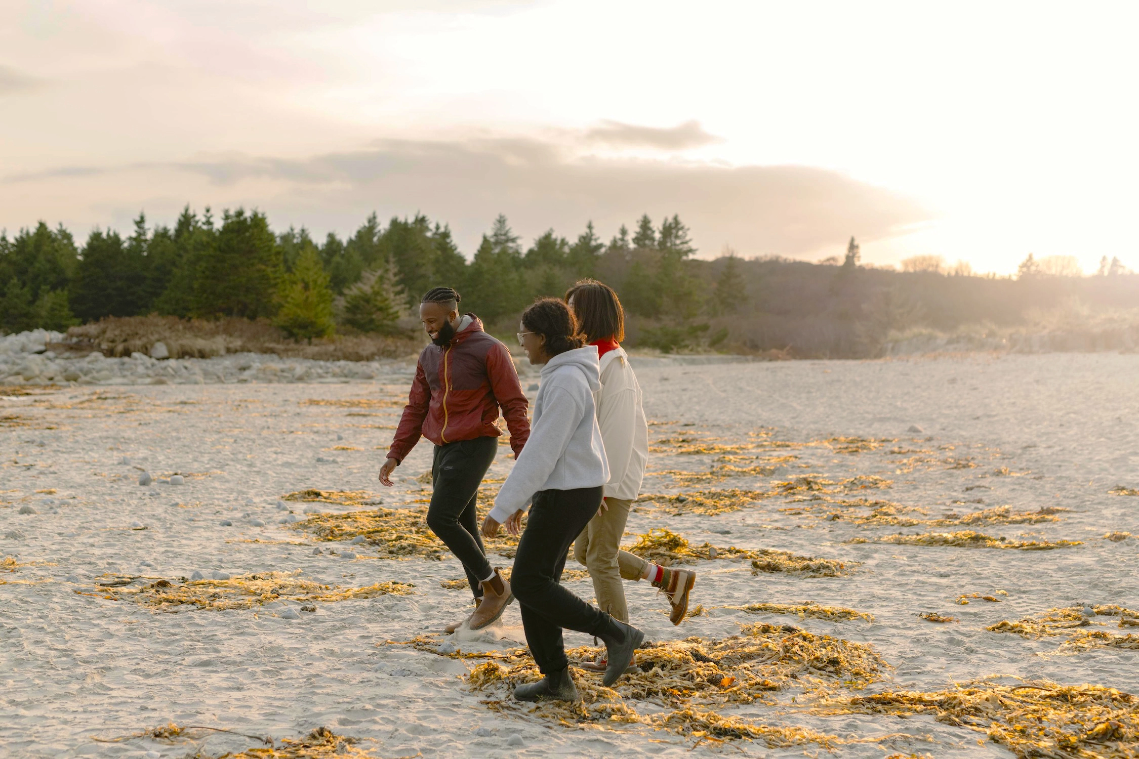 3 people walk on the beach in spring