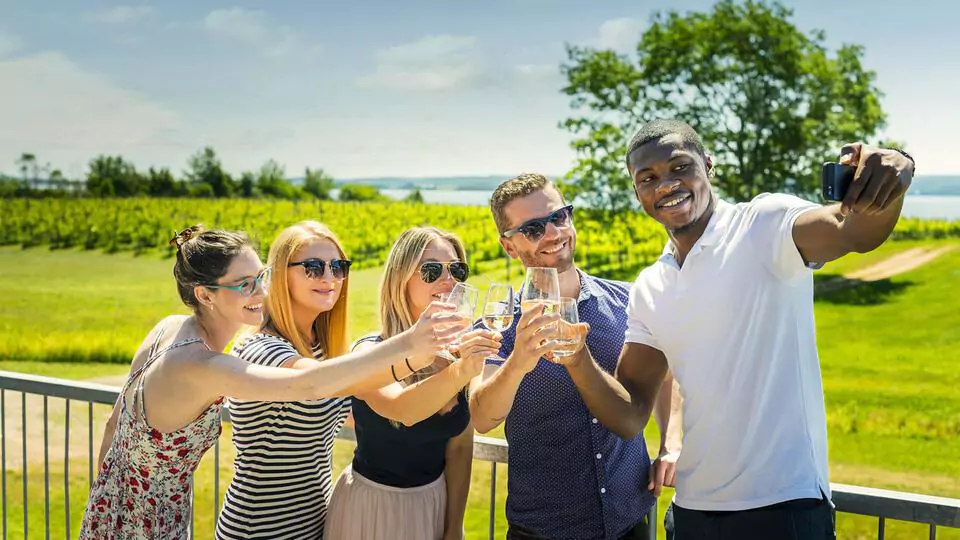 Friends taking a selfie on the deck at Blomidon Estate Winery in Nova Scotia's Annapolis Valley