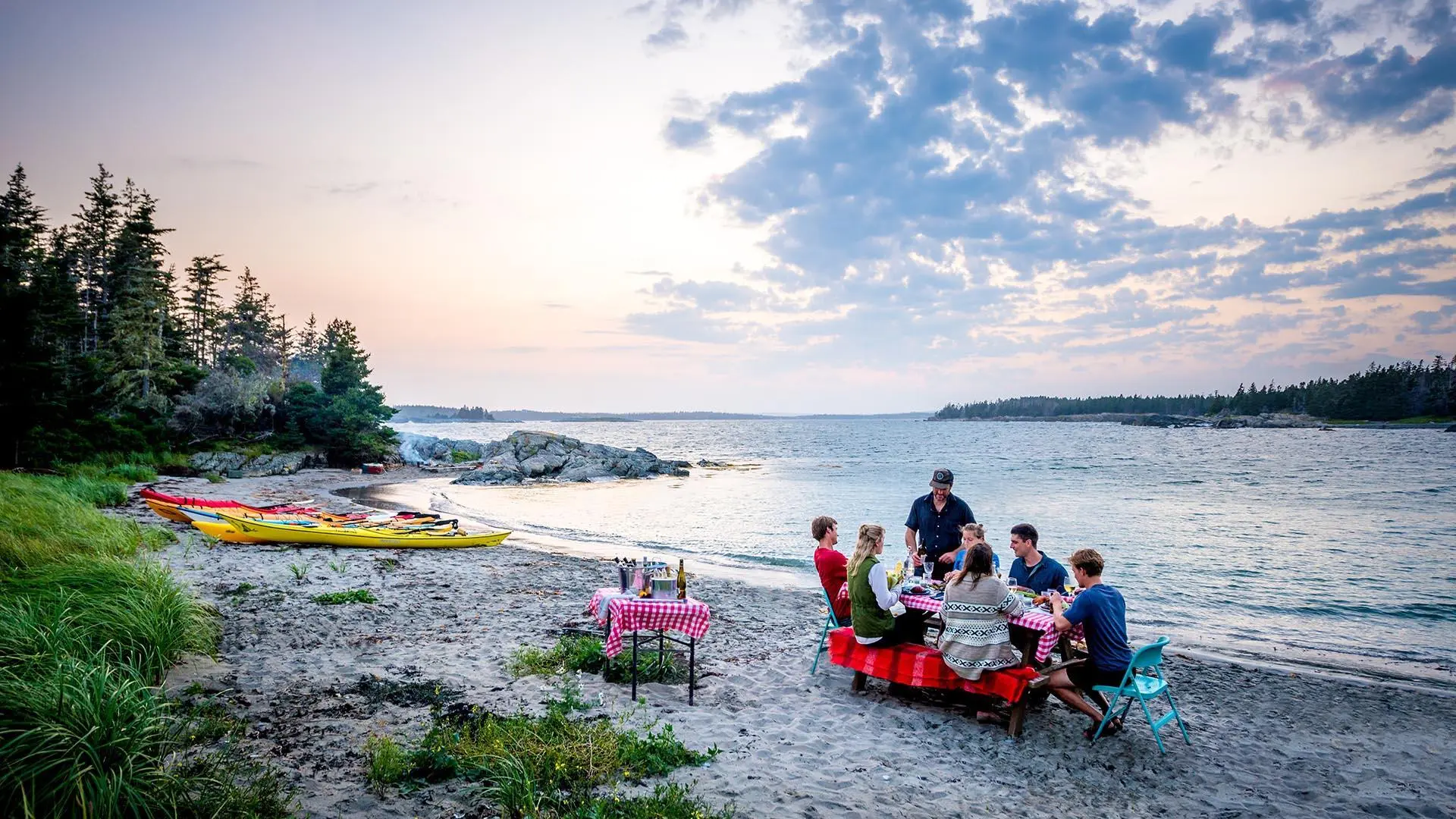 People sitting at picnic table on the beach