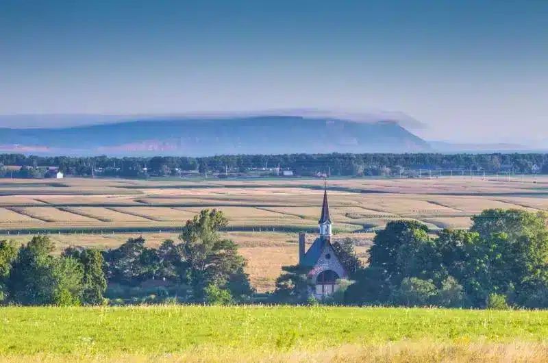 The church at Grand Pre National Historic Site and rolling fields of the area are seen from afar.