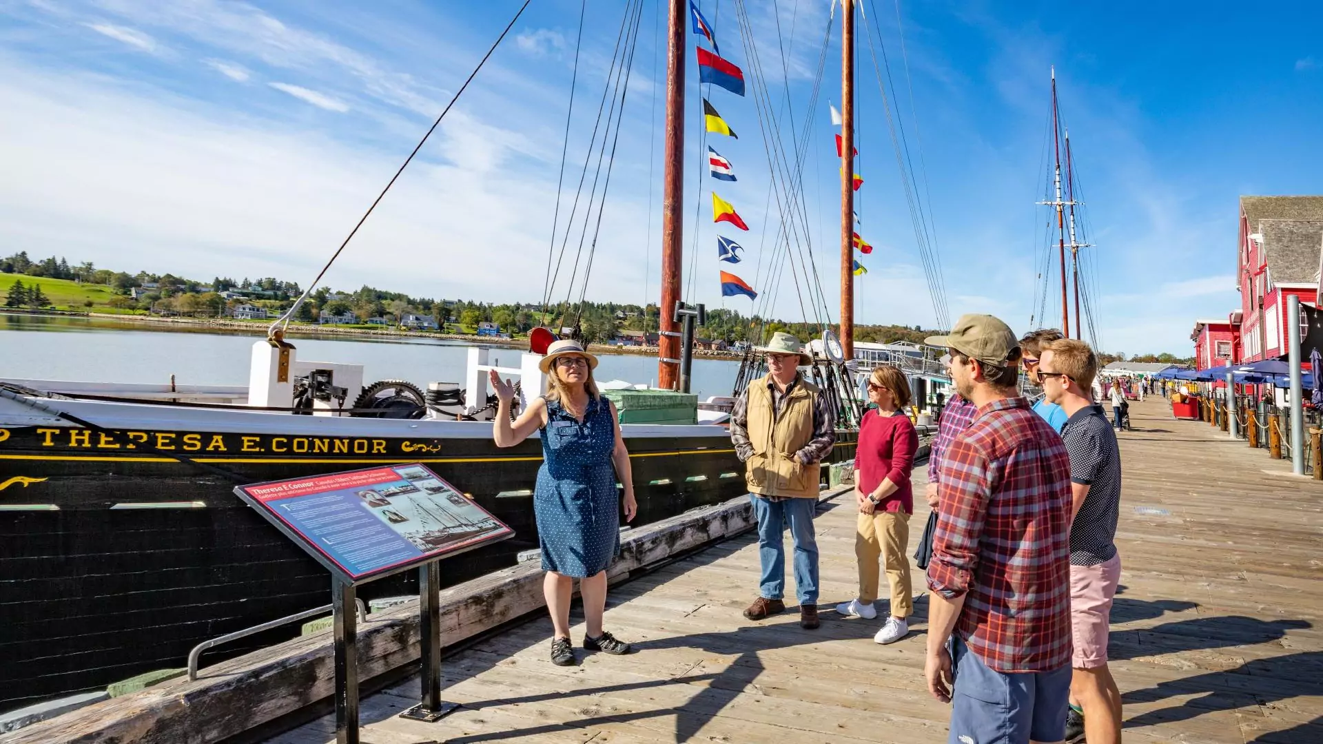 A tour guide is giving a walking tour of the Lunenburg Waterfront.